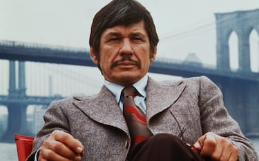 (Original Caption) New York, New York: Publicity handout from Death Wish shows Charles Bronson seated on the banks of the East River with the Brooklyn Bridge in the background. 1974.