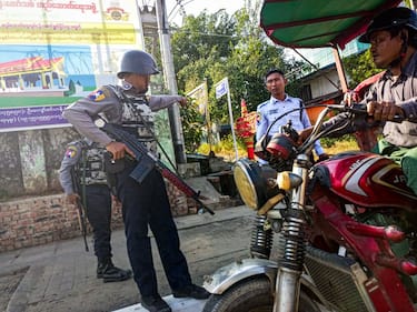 Armed policemen inspect a tricycle at a roadside checkpoint during the visit of the Myanmar junta leader Min Aung Hlaing to Thanlyin township, on the outskirts of Yangon on December 24, 2022.
 (Photo by STR/NurPhoto via Getty Images)