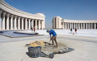 Workers filling op joints between the tiles at the newly built Arc de Triomphe in Egypt's New Administrative Capital.
Following persistent problems of overpopulation, pollution and traffic congestion, the construction of a giant new satellite city in the desert east of the current capital started in 2015. This New Administrative Capital (NAC) is part of President Al-Sisi’s Egypt Vision 2030, a long-term plan to develop Egypt. The future population of the NAC is estimated at 6 million. Critics predict a growing socio-economic gap between the New Capital and old Cairo, left to its own devices. Instead of solving existing problems, Egypt Vision 2030 seems to be a prestigious political project aimed at the expansion of the power apparatus, surveillance and global leadership.