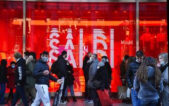 Persone davanti a una vetrina con articoli in saldo
