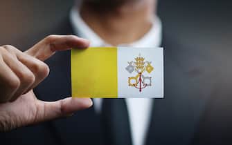 Businessman Holding Card of Vatican City Flag