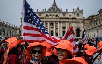 People gather with US flags at St Peter's square with the St Peter's Basilica in the background on the day Pope Leo XIV leads the Regina Caeli prayer, in the Vatican, on May 11, 2025. (Photo by JEFF PACHOUD / AFP)