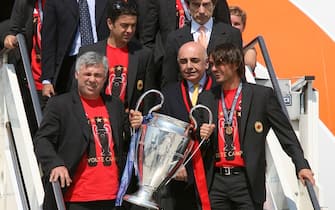 MILAN, ITALY - MAY 24: AC Milan coach Carlo Ancelotti (L) holds the Champion's League trophy with Paolo Maldini followed by Vice-President Adriano Galliani (C) during their arrival at the Malpensa Airport on May 24, 2007 in Milan, Italy. (Photo by Getty Images)