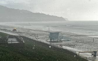 A Los Angeles County Lifeguard vehicle (L) drives on the beach as hail and rain fall during a winter storm that blanketed the region in Redondo Beach, California, on February 25, 2023. - Heavy snow fell in southern California as the first blizzard in a generation pounded the hills around Los Angeles, with heavy rains threatening flooding in other places. (Photo by Patrick T. Fallon / AFP) (Photo by PATRICK T. FALLON/AFP via Getty Images)