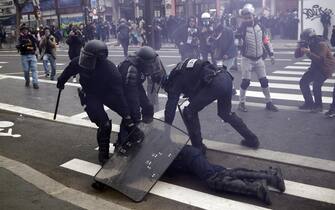 epa10538821 French police officers protect a colleague injured during clashes with protesters as thousands of people participate in a protest against the government's reform of the pension system in Paris, France, 23 March 2023. Protests continue in France after the prime minister announced on 16 March 2023 the use of Article 49 paragraph 3 (49.3) of the French Constitution to have the text on the controversial pension reform law - raising retirement age from 62 to 64 - be definitively adopted without a vote.  EPA/YOAN VALAT