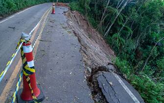 asphalt road damaged by a landslide in a mountain area.