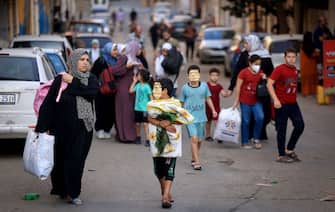 Palestinians carrying their belongings flee to safer areas in Gaza City after Israeli air strikes, on October 13, 2023. Israel has called for the immediate relocation of 1.1 million people in Gaza amid its massive bombardment in retaliation for Hamas's attacks, with the United Nations warning of "devastating" consequences. (Photo by MAHMUD HAMS / AFP) (Photo by MAHMUD HAMS/AFP via Getty Images)