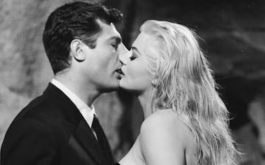 1960:  Marcello Mastroianni (1924 - 1996) and Anita Ekberg share a screen kiss in 'La Dolce Vita', directed by Federico Fellini.  (Photo via John Kobal Foundation/Getty Images)