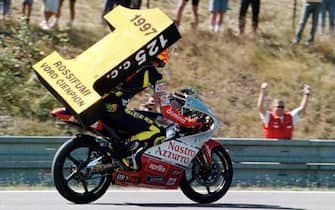 Valentino Rossi mostra trionfante un gigantesco numero 1 per il titolo mondiale delle 125 cc a Brno, in una immagine del 31 agosto 1997. ANSA/IGOR ZHEL/DRN