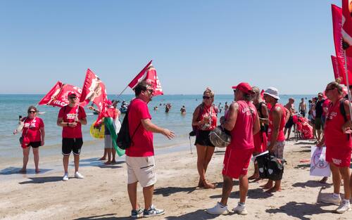 Sciopero simbolico dei bagnini oggi lungo il litorale della provincia di Rimini, dove i lavoratori del servizio di salvataggio hanno protestato per chiedere condizioni lavorative più eque. Al centro della mobilitazione, la richiesta di turni più sostenibili, nuove assunzioni e un servizio di salvataggio strutturato in maniera più sicura ed efficiente.

La protesta, indetta nel pieno della stagione estiva, non ha comportato interruzioni del servizio: grazie alla precettazione disposta dalla Prefettura, i bagnini hanno comunque garantito la sorveglianza in torretta, mentre la manifestazione si è svolta in forma ordinata.

Il corteo è partito intorno alle 12.30 dalla zona dei bagni 36-37 di Rimini, snodandosi lungo il litorale fino a raggiungere il piazzale Boscovich. Nessun disagio segnalato per i turisti presenti in spiaggia. Rimini, 9 agosto 2025. ANSA/Ph Dorin Mihai, Pasquale Bove

____

EN:

Italy: Rimini lifeguards hold symbolic strike, no impact on beach safety. Prefect orders mandatory service

RIMINI, Italy, Aug 9 (ANSA) – Lifeguards along Rimini’s coastline staged a symbolic strike on Saturday to protest working conditions during the peak summer season. The workers are demanding more manageable shift schedules, additional personnel, and improved safety protocols for rescue operations.

Despite the strike announcement, no disruption to beach safety was reported. Under an order issued by the Prefect, lifeguards were required to remain at their posts, ensuring continuous coverage of the shoreline.

The demonstration, which unfolded without incident, included a peaceful march beginning at 12:30 p.m. near Rimini bathing areas 36–37 and proceeding along the seafront to Piazzale Boscovich. Tourists and beachgoers were largely unaffected. Rimini (Italy) august 9 2025, ANSA/Ph Dorin Mihai, Pasquale Bove