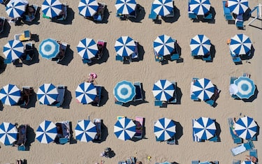 An aerial photograph taken on August 22, 2020, shows parasols on a beach of the Adriatic Sea in Durres, as a heatwave sweeps through Europe. - Due to the Covid 19 pandemic, the number of tourists entering Albania dropped by 66 percent. The majority of tourists are domestic or from the neighbouring Kosovo and North Macedonia. (Photo by Gent SHKULLAKU / AFP) (Photo by GENT SHKULLAKU/AFP via Getty Images)