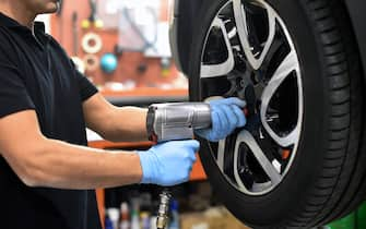 Mechanic changing a car tire in a workshop