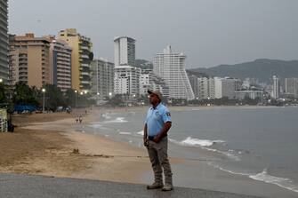 Un poliziotto pattuglia la spiaggia di Acapulco in Messico in attesa dell'uragano Otis
