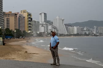 Un poliziotto pattuglia la spiaggia di Acapulco in Messico in attesa dell'uragano Otis