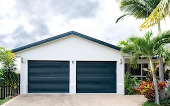 Freshly painted house with double garage, gable end and tropical garden
