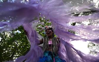 A reveler takes part in a parade of the street carnival group Loucura Suburbana (Suburban Craziness) at the Engenho de Dentro neighborhood in the suburbs of Rio de Janeiro, Brazil on February 8, 2024. The "Loucura Suburbana" street carnival group is organized by workers and patients of the Nise da Silveira Municipal Psychiatric Hospital. The parade starts inside the hospital and winds its way through the streets of the neighborhood. (Photo by MAURO PIMENTEL / AFP)