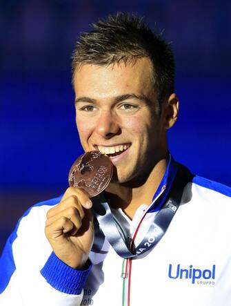 epa03813222 Gregorio Paltrinieri of Italy poses with his bronze medal on the podium of the men's 1,500m Freestyle final during the 15th FINA Swimming World Championships at Palau Sant Jordi arena in Barcelona, Spain, 04 August 2013.  EPA/ANDREU DALMAU