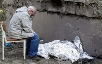 Un anziano guarda il cadavere della nipote a Kiev