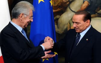 Il passaggio della campanella tra il premier uscente Silvio Berlusconi e il neo presidente del Consiglio Mario Monti a palazzo Chigi a Roma, il 16 novembre 2011. ANSA / MAURIZIO BRAMBATTI