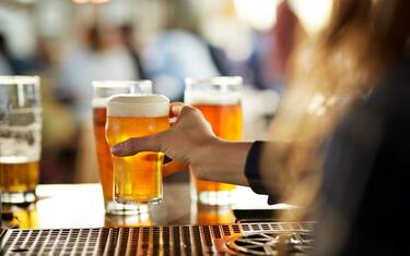 Close-up of bartender serving beers at bar