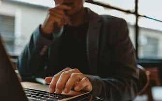 Close-up of a businessman working on laptop. Hand of a male executive working on laptop in office.