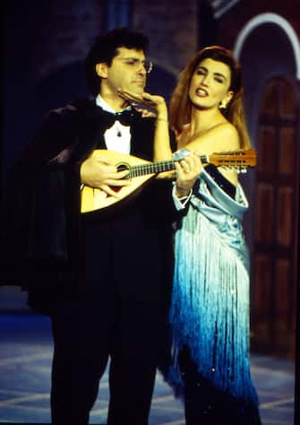 Italian tv-host Fabrizio Frizzi plays a mandolin with his colleague tv-host Milly Carlucci (Camilla Patrizia Carlucci) during a tv show. 1990 (Photo by Archivio Apg/Mondadori Portfolio via Getty Images)