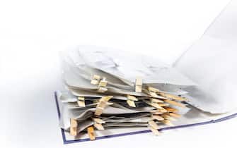 Ring binder or document folder with transparent punched pockets full of receipts closed with wooden clothespins, accounting and tax calculation, offic