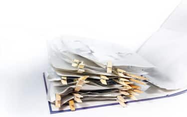 Ring binder or document folder with transparent punched pockets full of receipts closed with wooden clothespins, accounting and tax calculation, offic
