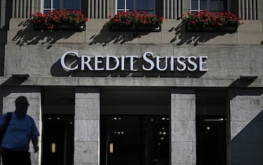 A man walks next to a branch of Swiss banking giant Credit Suisse in Bern on August 15, 2022. - Switzerland's scandal-hit banking giant Credit Suisse last month appointed a new chief executive as higher litigation costs, financial market volatility and rising interest rates worldwide pushed it deeper into the red in the second quarter. (Photo by Fabrice COFFRINI / AFP) (Photo by FABRICE COFFRINI/AFP via Getty Images)