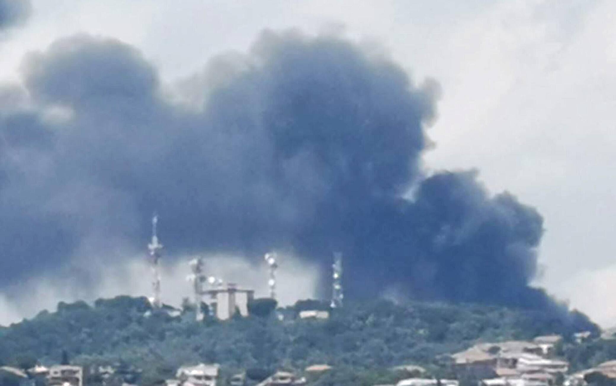 La colonna di fumo alta e densa causto da un incendio in un deposito di automezzi a San Gregorio, comune della provincia di Catania, 31 luglio 2022. ANSA