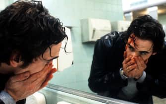 Matt Dillon looking at blood streaming down his face in mirror in a scene from the film 'Drugstore Cowboy', 1989. (Photo by Avenue Pictures Productions/Getty Images)