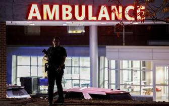 epa10939758 A police officer stands guard in front of the Central Maine Medical Center after a man reportedly opened fire killing and injuring numerous people in Lewiston, Maine, USA, 25 October 2023. Early reports indicate as many as 20 people have been killed, and dozens injured. Police are still searching for the suspect.  EPA/CJ GUNTHER