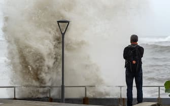 A man looks at the waves at the malecon during high tide after Hurricane Beryl in Santo Domingo on July 2, 2024. Hurricane Beryl was hurtling towards Jamaica on July 2, as a monster Category 5 storm, after killing at least five people and causing widespread destruction in a deadly sweep across the southeastern Caribbean. (Photo by Francesco SPOTORNO / AFP) (Photo by FRANCESCO SPOTORNO/AFP via Getty Images)