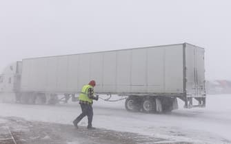 A truck driver runs to his truck at the Flying J Travel Center during a blizzard in Williams, Iowa on January 12, 2024. Photo by Julia Nikhinson/ABACAPRESS.COM
