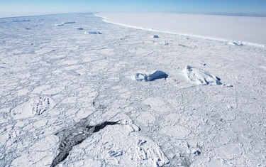 UNSPECIFIED, ANTARCTICA - OCTOBER 31:  The western edge of the famed iceberg A-68 (TOP R), calved from the Larsen C ice shelf, is seen from NASA's Operation IceBridge research aircraft, near the coast of the Antarctic Peninsula region, on October 31, 2017, above Antarctica. The massive iceberg was measured at approximately the size of Delaware when it first calved in July. NASA's Operation IceBridge has been studying how polar ice has evolved over the past nine years and is currently flying a set of nine-hour research flights over West Antarctica to monitor ice loss aboard a retrofitted 1966 Lockheed P-3 aircraft. According to NASA, the current mission targets 'sea ice in the Bellingshausen and Weddell seas and glaciers in the Antarctic Peninsula and along the English and Bryan Coasts.' Researchers have used the IceBridge data to observe that the West Antarctic Ice Sheet may be in a state of irreversible decline directly contributing to rising sea levels. The National Climate Assessment, a study produced every 4 years by scientists from 13 federal agencies of the U.S. government, released a stark report November 2 stating that global temperature rise over the past 115 years has been primarily caused by 'human activities, especially emissions of greenhouse gases'.  (Photo by Mario Tama/Getty Images)