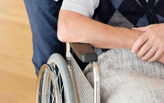 Caregiver pushing older man in wheelchair