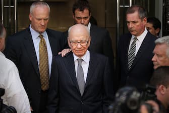 LONDON, ENGLAND - JULY 15:  News Corp. Chairman Rupert Murdoch (C) looks down as he leaves the One Aldwych Hotel surrounded by his personal security team to speak with reporters after meeting with the family of murdered school girl Milly Dowler on July 15, 2011 in London, England. News International Chief Executive Rebekah Brooks has announced her resignation.  (Photo by Peter Macdiarmid/Getty Images)