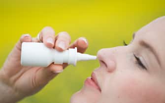 Una donna usa uno spray nasale