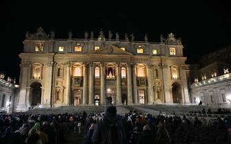 Faithful gather in front of the basilica at St Peter's square during the Christmas Eve mass  in the Vatican on December 24, 2024. Pope Francis marks Christmas Eve with a special ceremony launching Jubilee 2025, a year of Catholic celebrations set to draw more than 30 million pilgrims to Rome. Over the next 12 months, pilgrims will pass through the large and imposing bronze door, which is normally closed, by tradition benefiting from a "plenary indulgence", a type of forgiveness for their sins. (Photo by Alberto PIZZOLI / AFP)