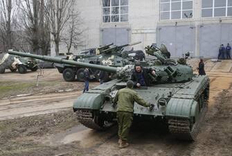 epa05079478 Ukrainian workers talk near a tank which was delivered for repair at the armored vehicles factory in Kiev, Ukraine, 23 December 2015. The United States a day earlier expanded its list of Russian individuals and entities sanctioned over the Ukraine conflict in an effort to push Russia to enforce a ceasefire deal clinched earlier this year in Minsk. The sanctions also include six pro-Russian separatists and two former Ukrainian officials close to Ukraine's ousted pro-Russian president Viktor Yanukovych. Ukraine ousted Yanukovych last year amid mass protests calling for closer ties with the West. Russia subsequently annexed Ukraine's southern Crimea region and supported a pro-Russian separatist rebellion in Ukraine's two eastern-most regions.  EPA/SERGEY DOLZHENKO