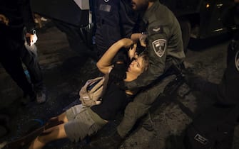 JERUSALEM, ISRAEL - JULY 24: An injured protester is carried by a police officer during a demonstration near the Israeli Knesset on July 24, 2023 in Jerusalem, Israel. Some 20,000 anti-government protestors marched from Tel Aviv and converged in Jerusalem outside parliament as the controversial bill was being voted on, after weeks of protest against the government's plans to restrain the judiciary.  (Photo by Amir Levy/Getty Images)