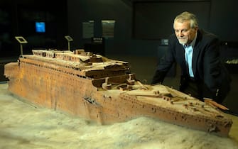 Paul-Henry Nargeolet, director of a deep ocean research project dedicated to the Titanic, poses next to a miniature version of the sunken ship inside a new exhibition, at 'Paris Expo', on May 31, 2013, in Paris. Over a century after the sinking of the famous ship, a Titanic exhibition in Paris will open to public from June 1 to September 15, and promises to present "real objects, and real stories".  AFP PHOTO / JOEL SAGET        (Photo credit should read JOEL SAGET/AFP via Getty Images)