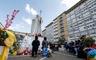 People under the statue of late Pope John Paul II outside Agostino Gemelli Hospital. Pope Francis will be discharged today with prescription for two months of rest after spending more than five weeks in the hospital or a bilateral pneumonia, Italy, 23 March 2025. ANSA/GIUSEPPE LAMI