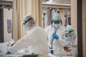 Operatori sanitari, che indossano tute protettive mediche e mascherine, al lavoro nella  terapia intensiva dell'Ospedale Sant'Orsola di Bologna, 12 novembre 2020. Ansa/Max Cavallari