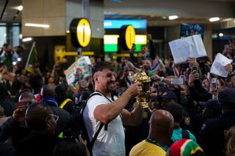 epa10950282 Springbok rugby team player Eben Etzebeth (C) poses with the William Webb Ellis Cup upon the team's arrival in the country after winning the 2023 Rugby World Cup, in Johannesburg, South Africa, 31 October 2023. The Springboks won back to back Rugby World Cups and are the only team to have won four titles. They will embark on a trophy tour around the country starting 02 November.  EPA/KIM LUDBROOK