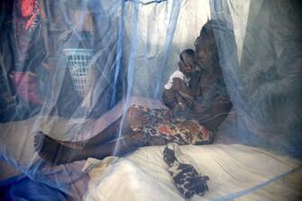 epa05925288 Zamble Lou Irie Sabine, 28 years, holds her three month old child Yao Melvin, under a mosquito net in Abidjan, Ivory Coast, 24 April 2017. World Malaria Day is observed on 25 April each year to recognize the global efforts to control Malaria, it was established in May 2007 by the World Health Organization (WHO).  EPA/LEGNAN KOULA