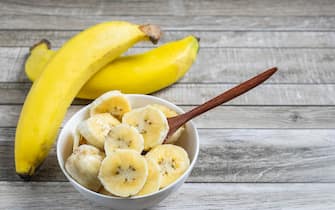 Fresh bananas and bananas cut into pieces in a bowl for health on the table.