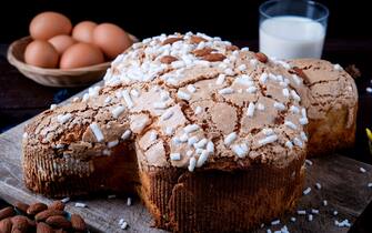 Traditional Italian desserts for Easter - Easter dove . Festive pastries with almonds and sugar icing dark background Easter decor and eggs