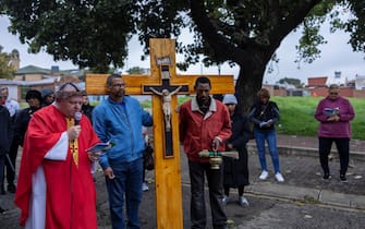 Venerdì Santo in Sudafrica epa12038320 Father PJ Cassidy (L) and members of the congregation of the St. Francis Xavier Martindale Church ca rry a cross as they walk the streets of the Westburg suburb marking Good Friday in Johannesburg, South Africa, 18 April 2025. Father PJ Cassidy and his congregation walked the streets of Westburg on Good Friday, praying for peace and sharing God s word in a suburb gripped by drugs, violence, and poverty. EPA/KIM LUDBROOK