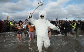 NEW YORK, NY - JANUARY 01: A man dressed as a polar bear walks into the ocean during the annual Coney Island Polar Bear Club New Year's Day swim on January 1, 2016 in the Brooklyn borough of New York City. The Coney Island Polar Bear Club claims to be the oldest winter bathing organization in the U.S. and attracts hundreds to the beach for the annual swim in the Atlantic Ocean. (Photo by Stephanie Keith/Getty Images)